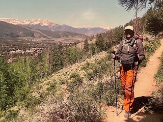 a man hiking up a trail in the mountains