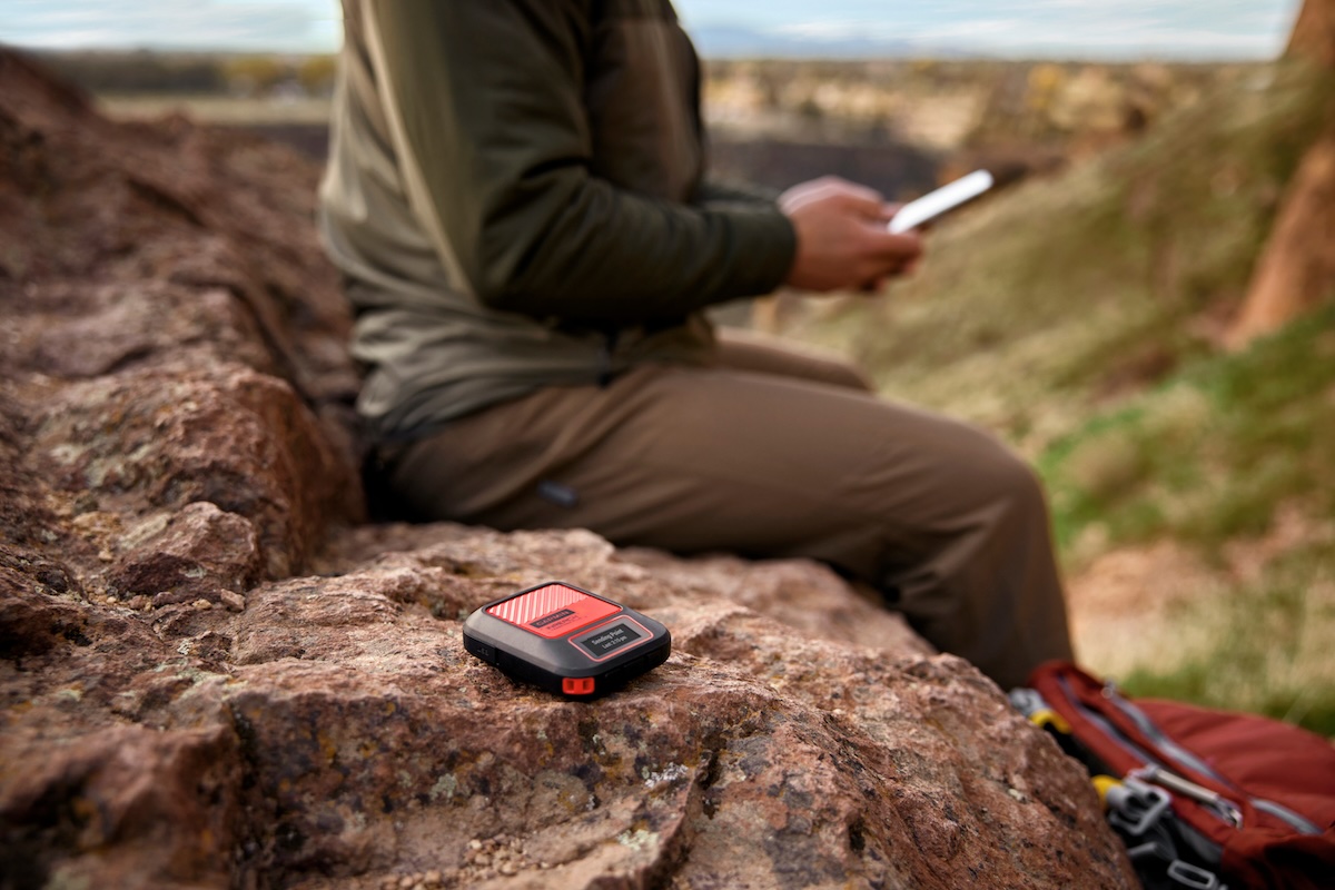 garmin inreach messenger plus being used by a person on a rock with their smartphone