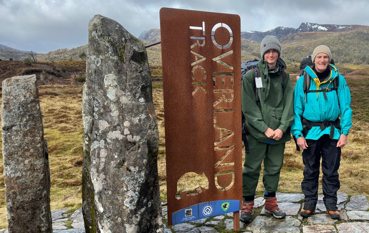 Two hikers next to Overworld Track sign