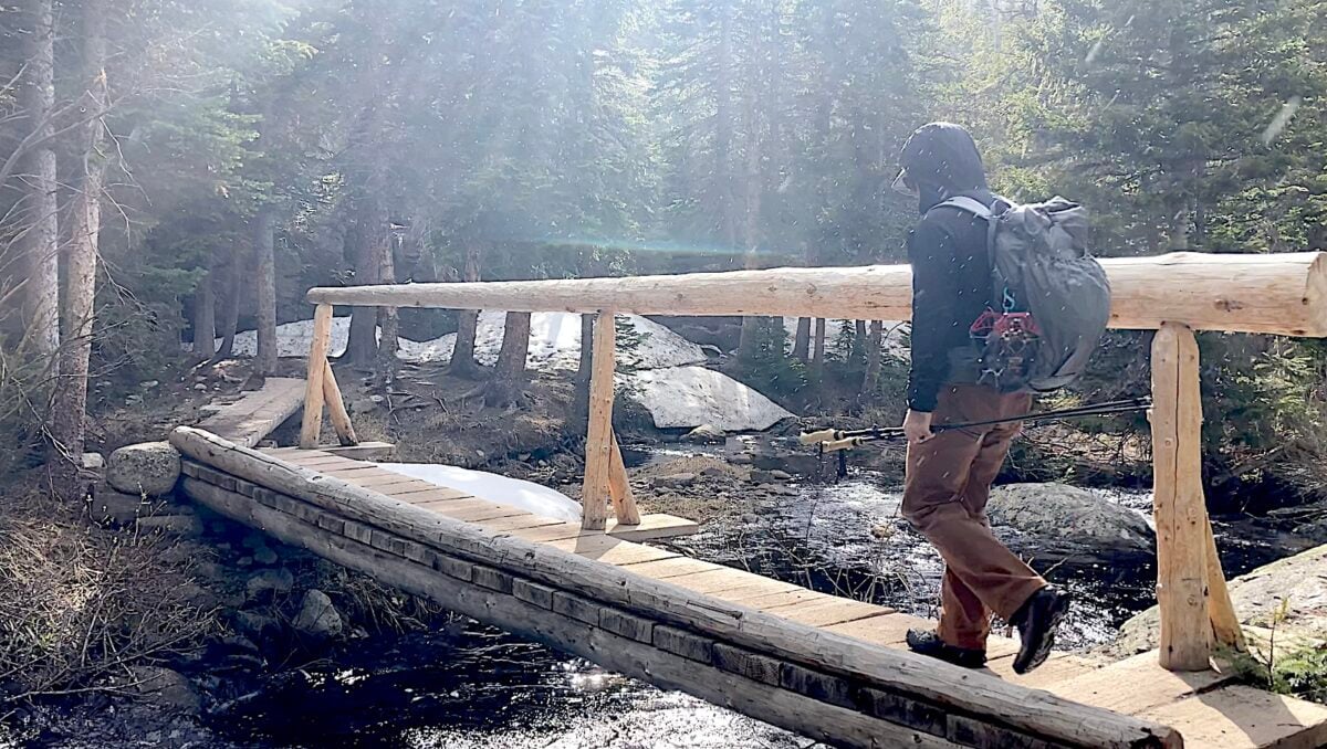 man wearing backpacking over bridge