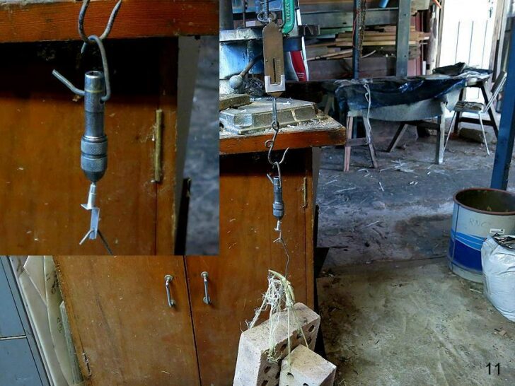 Workshop setup showing a hanging weight test on a small metal component.