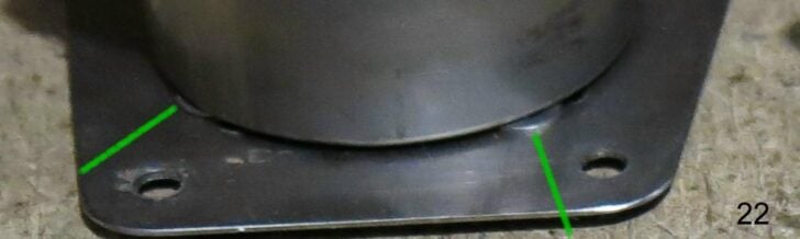 Close-up of stove body mounted to a metal base plate.
